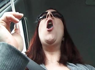 Redhead lights up in the car and smokes