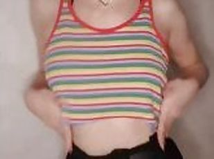 A beautiful girl in a colorful T-shirt dances in front of the camera