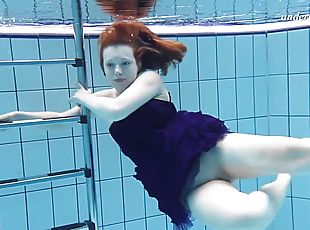 Russian redhead babe displaying her shaved pussy when swimming